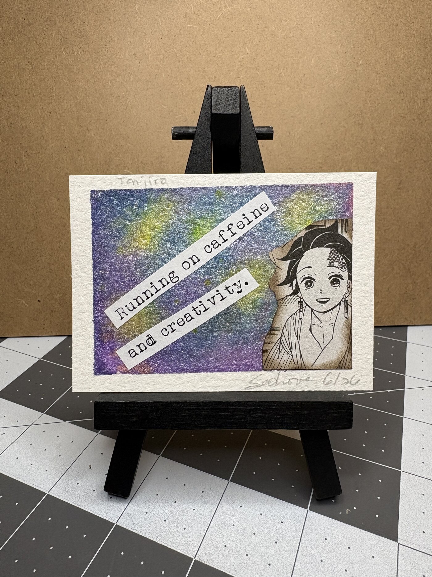 Tanjiro ACEO original watercolor on a mini easel, with the text "Running on caffeine and creativity."